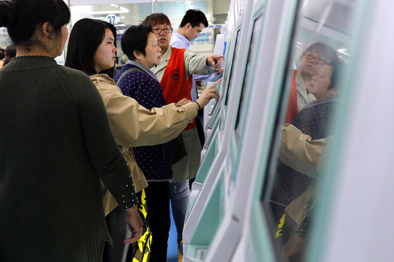 4月8日，北京宣武医院工作人员帮助患者用挂号机挂号。